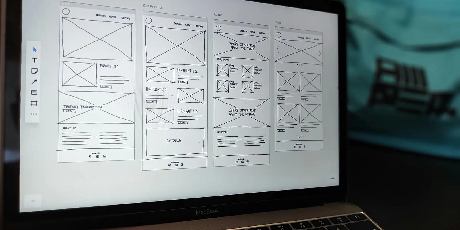 A laptop screen showing four hand-drawn page wireframes side by side in a design tool.